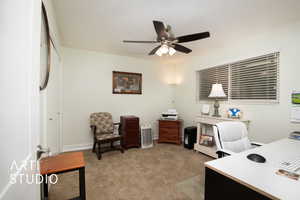 Home office with ceiling fan and light colored carpet