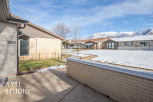 Snow covered patio featuring a mountain view