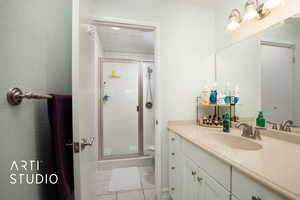 Bathroom featuring tile patterned flooring, vanity, toilet, and walk in shower