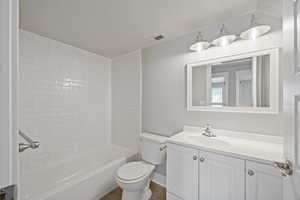 Full bathroom with vanity, toilet, and tiled shower / bath combo