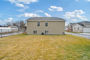 Rear view of property with a yard