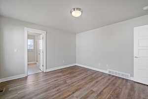 Empty room with hardwood / wood-style flooring