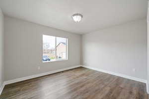 Spare room featuring dark wood-type flooring