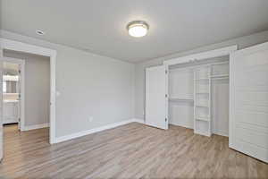 Unfurnished bedroom with light hardwood / wood-style flooring and a closet