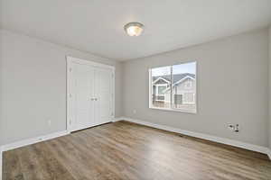 Unfurnished bedroom featuring wood-type flooring and a closet