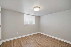 Unfurnished room featuring light hardwood / wood-style flooring and a textured ceiling