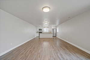 Unfurnished living room featuring a textured ceiling and light wood-type flooring