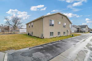 View of home's exterior with a yard and central AC