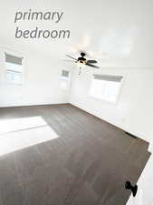 Carpeted empty room with ceiling fan and a healthy amount of sunlight