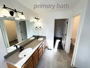 Bathroom featuring hardwood / wood-style flooring, vanity, and toilet