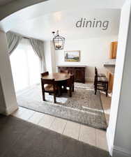 Dining room featuring a textured ceiling, an inviting chandelier, and light tile patterned flooring