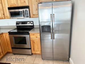 Kitchen featuring light tile patterned floors and stainless steel appliances