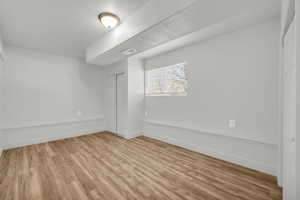 Spare room with a textured ceiling and light hardwood / wood-style floors