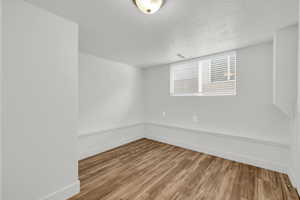 Unfurnished room with wood-type flooring and a textured ceiling