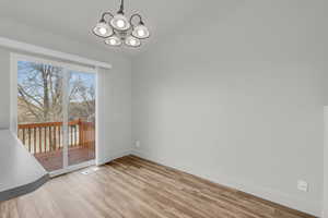 Unfurnished dining area featuring light hardwood / wood-style flooring and an inviting chandelier