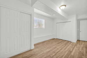 Unfurnished bedroom with light wood-type flooring and a textured ceiling