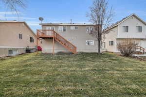 Rear view of property with a deck and a yard