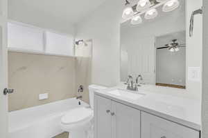 Full bathroom with ceiling fan, toilet, shower / bath combination, and vanity