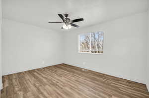 Empty room featuring ceiling fan and hardwood / wood-style floors