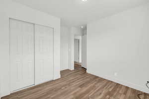 Unfurnished bedroom with light wood-type flooring and a closet