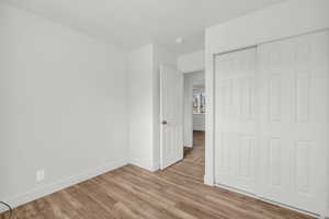 Unfurnished bedroom with a closet and light hardwood / wood-style flooring