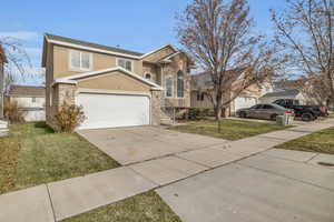 View of front of home featuring a garage and a front lawn