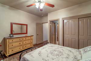 Bedroom with ceiling fan, a closet, and dark hardwood / wood-style floors