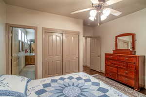 Bedroom with connected bathroom, a closet, and ceiling fan