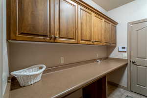 Clothes washing area featuring light tile patterned flooring