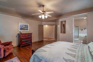 Bedroom with ceiling fan, dark wood-type flooring, and ensuite bathroom