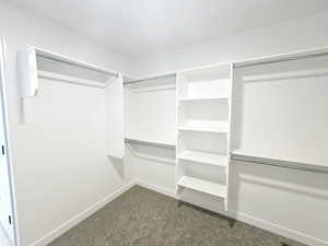 Walk in closet featuring dark carpet