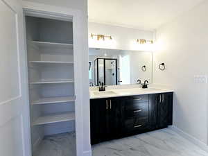 Bathroom with vanity and a shower with door