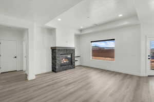 Unfurnished living room featuring a fireplace and light hardwood / wood-style floors