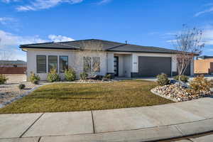 View of front of house featuring a garage and a front lawn