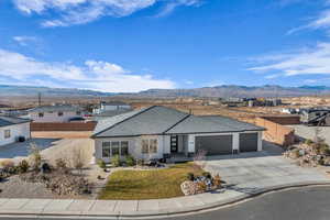 Single story home featuring a mountain view, a front lawn, and a garage