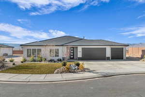 View of front of property with a mountain view, a garage, and a front yard