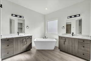 Bathroom featuring hardwood / wood-style floors, a bathtub, and vanity