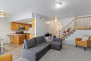 Living room with a textured ceiling and light hardwood / wood-style floors