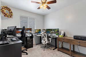 Home office featuring light colored carpet and ceiling fan