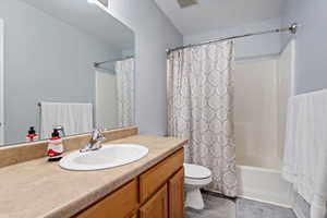 Full bathroom with vanity, shower / bath combo, and toilet