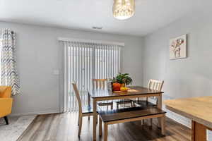 Dining area with hardwood / wood-style floors and an inviting chandelier