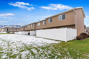 Snow covered rear of property featuring a mountain view