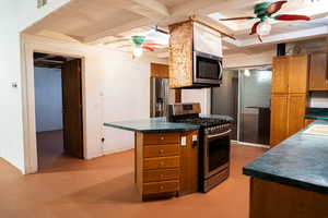 Kitchen featuring ceiling fan, sink, and appliances with stainless steel finishes