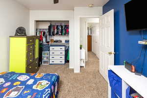 Carpeted bedroom featuring a closet