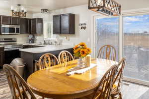 Dining area featuring sink, an inviting chandelier, and light wood-type flooring