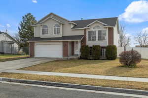 View of front facade featuring a front yard and a garage