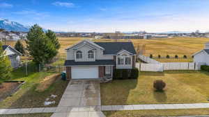 View of front facade with a mountain view, a garage, and a front lawn