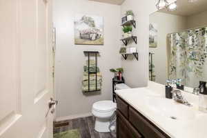 Bathroom with vanity, hardwood / wood-style flooring, and toilet