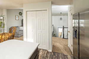 Bedroom with a closet, dark hardwood / wood-style floors, and stainless steel refrigerator with ice dispenser