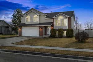 View of front facade featuring a lawn and a garage